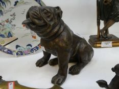 A modern bronze sculpture of seated bulldog