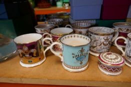 A large selection of china mugs mostly depicting themes of the British Royal family including Britan