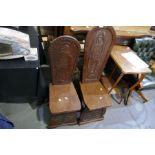 A mahogany hall chair having carved religious figure and one other slightly smaller hall chair