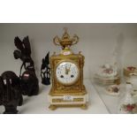 A late 19th Century French gilt metal and marble mantel clock with urn surmount, 8 day movement, hei