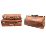 A Victorian leather gladstone bag with brass mounts; and two rectangular leather suitcases. (3)