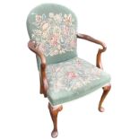 A Queen Anne style walnut armchair with arched back and shaped crook arms above a sprung upholstered