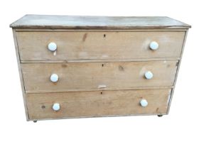 A Victorian pine chest of three long drawers mounted with white glazed porcelain knobs. (52in x 18.