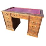 A Victorian oak kneehole desk, the rectangular moulded top with inset leatherette writing surface