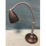 A 1950s chromed desk lamp with original cone shade on adjustable snake branch, above a column on