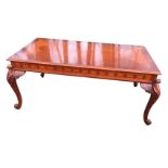 A reproduction mahogany coffee table, the crossbanded moulded top inlaid with oval panel above a