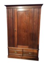 A late Victorian walnut wardrobe with moulded cornice above a chamfered panelled door enclosing