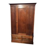 A late Victorian walnut wardrobe with moulded cornice above a chamfered panelled door enclosing