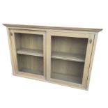 A glazed oak cabinet with moulded cornice above sliding glass doors enclosing an interior with
