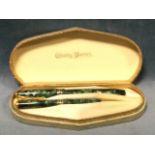 A cased Conway Stewart pen & propelling pencil set with malachite style marbleised bodies, the