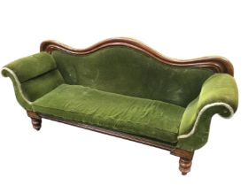 A Victorian mahogany parlour sofa with serpentine shaped moulded back and scrolled padded arms