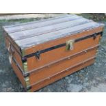 A rectangular cabin trunk with slatted mounts on hessian ground, the interior with tray, having