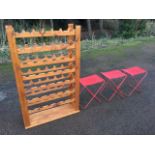 A rectangular pine wine rack designed to take 42 bottles; and a set of three canvas seated folding