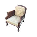 A late Victorian carved mahogany bergére armchair, the scalloped moulded back with scrolled