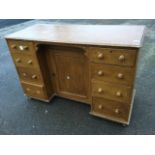 A Victorian scumbled pine kneehole desk, with rectangular moulded top above a central panelled