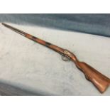 A replica wallpiece rifle with pine stock and tubular barrel bound with copper bands, with