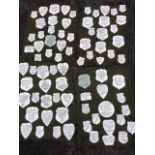 A collection of 77 Victorian milk glass memorial plaques, the shield shaped panels black glazed with