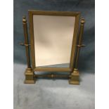 A Victorian brass dressing table mirror with rectangular plated in moulded frame supported on turned