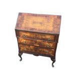 A Queen Anne style walnut bureau with crossbanded fallfront enclosing a fitted interior with two
