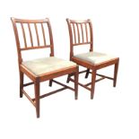 A pair of antique mahogany dining chairs with ribbed spindled backs above drop-in upholstered
