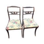 A pair of regency simulated rosewood chairs with twisted back rails above pierced scroll carved