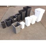A set of six graduated new square black plastic garden tubs; another similar set of four in white;
