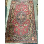 An Axminster oriental style rug woven with central rectangular scalloped medallion on red field