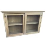 A glazed oak cabinet with moulded cornice above sliding glass doors enclosing an interior with