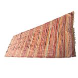 A rectangular kelim runner woven in russet colours with stripes and bands of triangular aztec type