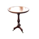 A circular tray-top mahogany wine table supported on a turned fluted column with tripartite legs