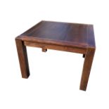 A contemporary stained oak dining table, the square panelled top raised on column legs. (43.5in x