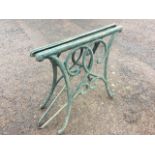 A cast iron garden table having ends with scrolled decoration on sabre legs - needs re-slatting to