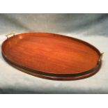 An oval Edwardian mahogany tray mounted with brass handles. (26.5in)