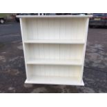 A painted open bookcase with moulded top above three shelves, having tongue & grooved back. (36.