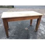 A solid oak kitchen table with rectangular moulded top on square tapering legs with spade feet. (