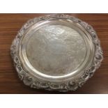 A nineteenth century style silver coloured salver with shell foliate scrolled embossed rim and