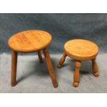 A Victorian style circular oak milking stool on four angled turned legs; and another on beech on