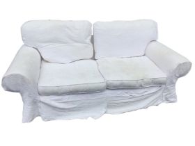 A contemporary country house sofa with loose cushions and padded arms, fitted with damask loose