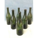 A set of six early nineteenth century olive glass wine bottles with deep kicked bases and moulded