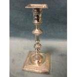 A Georgian style hallmarked silver candlestick with square gadroon moulded base supporting a