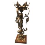 An art nouveau brass tablelamp mounted on square oak plinth, the central column with scrolled