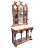 A Victorian pitch pine gothic hallstand, the pegged back in three sections having central mirror