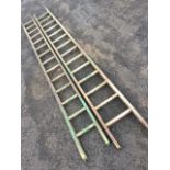 A two-piece wood extending ladder, each section with 14 turned rungs. (130in)