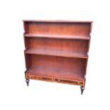 An open mahogany waterfall bookcase with graduated shelves above two satinwood crossbanded