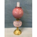 An Edwardian brass oil lamp with twin wicks and acid etched chimney, having pink toned vaseline