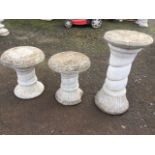 A pair of composition stone stools with circular lozenge moulded tops on twisted waisted columns