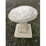 A composition stone garden staddlestone with mushroom shaped cap on square tapering column, with