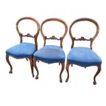 A set of three Victorian mahogany balloon back dining chairs, the moulded backs above scroll