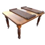 A late Victorian oak extending dining table, the rectangular moulded top with canted corners and two