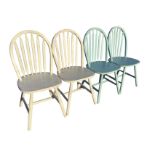 A set of four painted kitchen chairs with arched slat backs above rounded seats, raised on turned